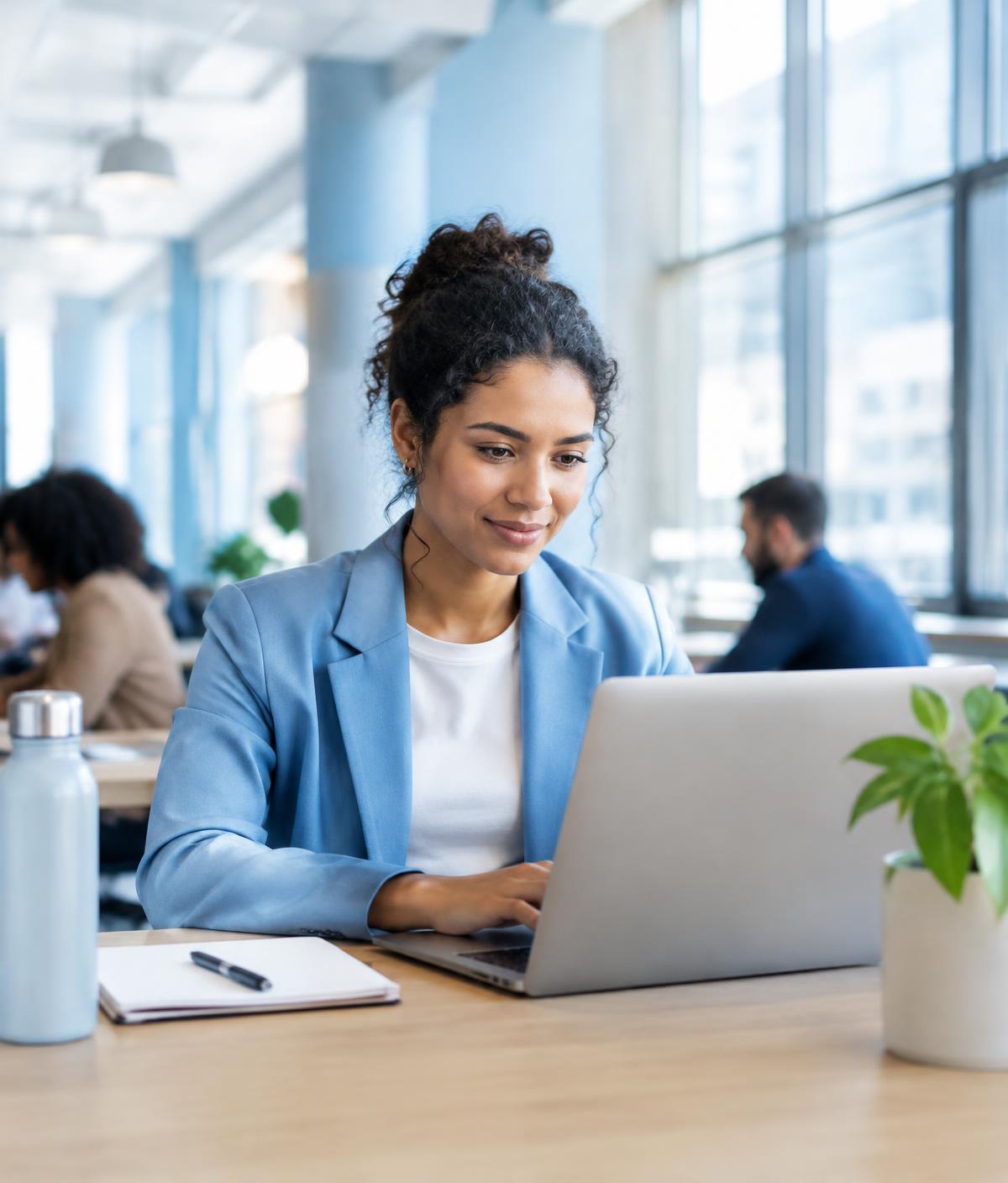 Professional working on a laptop in a bright modern workspace